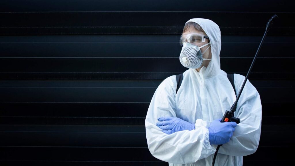 a person in a white suit and face mask ready for termite exterminator